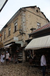 Beneden zijn de leuke winkels, maar erboven zitten de gebouwen vol kogelgaten.